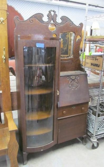 Antique brown wooden cabinet with glass door and writing desk.