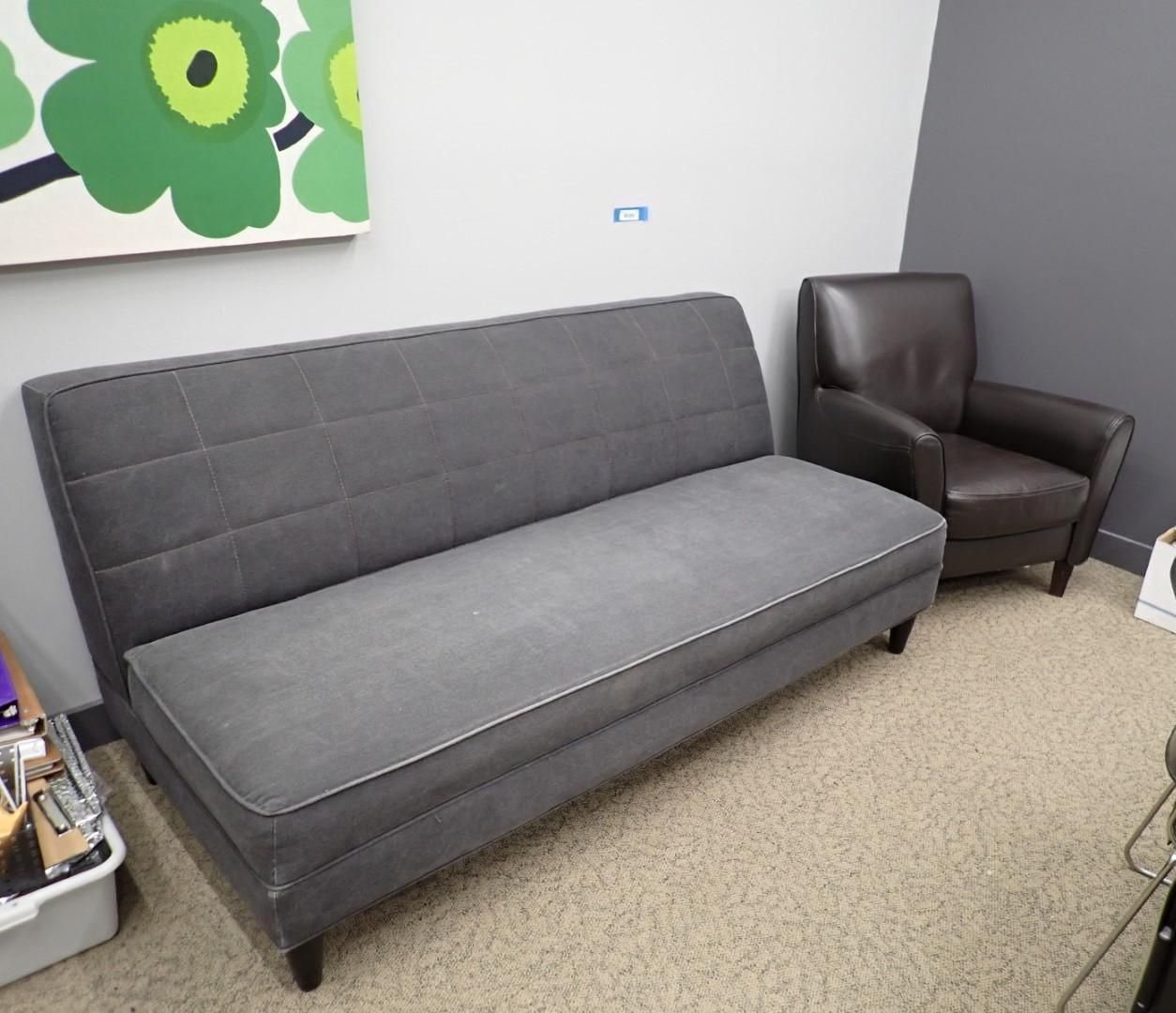 Gray couch and brown armchair in a room with a painting and beige carpet.