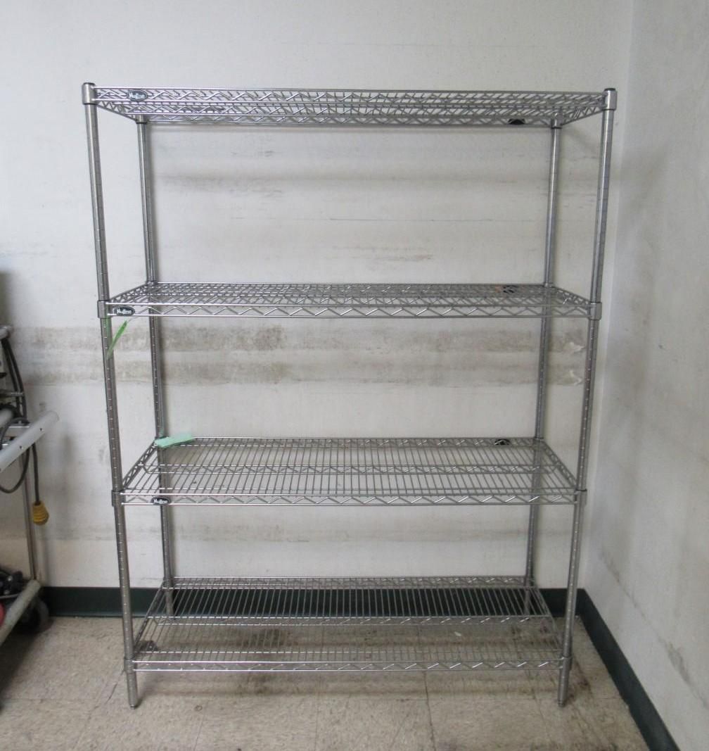 Metal wire shelving unit with three shelves in a room.
