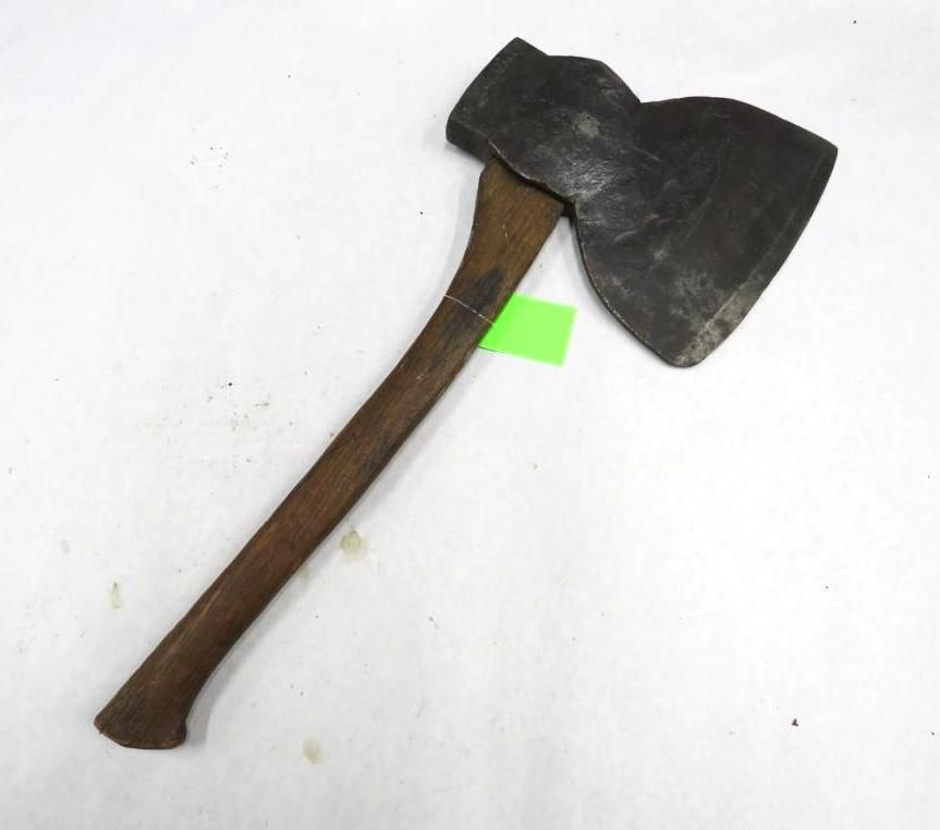 A axe with a wooden handle lies on a white surface.