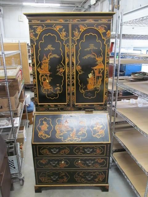 Black cabinet with gold detailing, including a desk and upper storage.