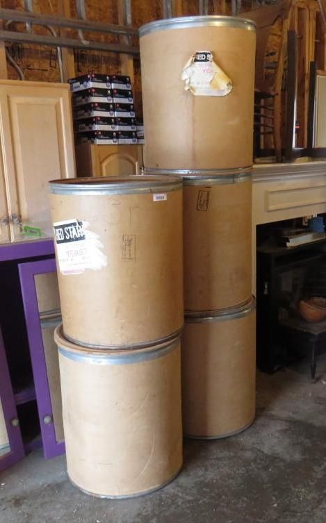 Six large, brown cardboard barrels stacked.