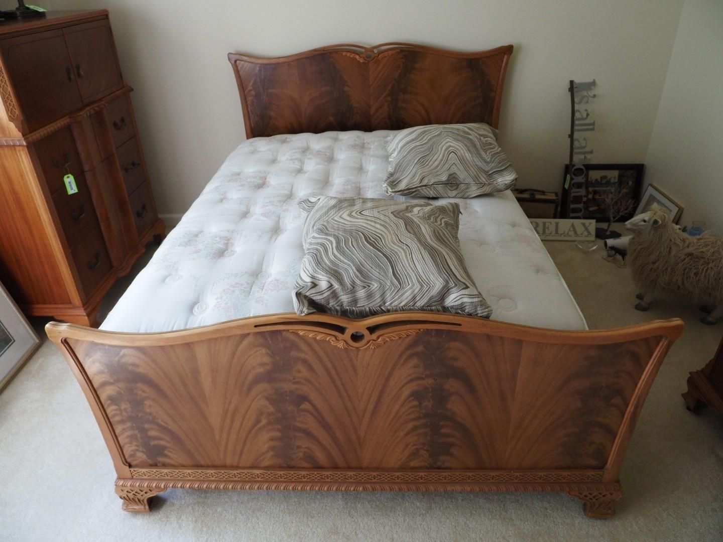 Wooden bed with ornate headboard and footboard.