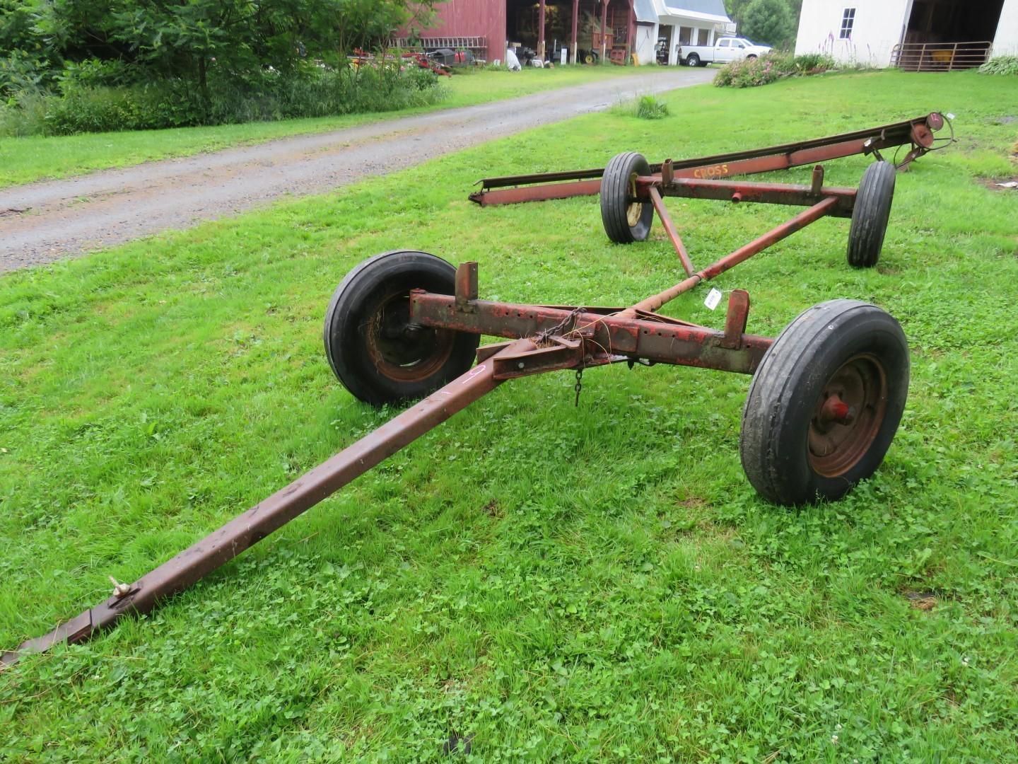 Farm wagon with four tires on green grass.