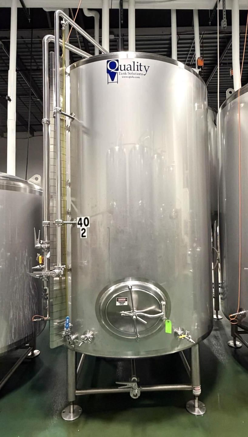 Stainless steel industrial tank labeled