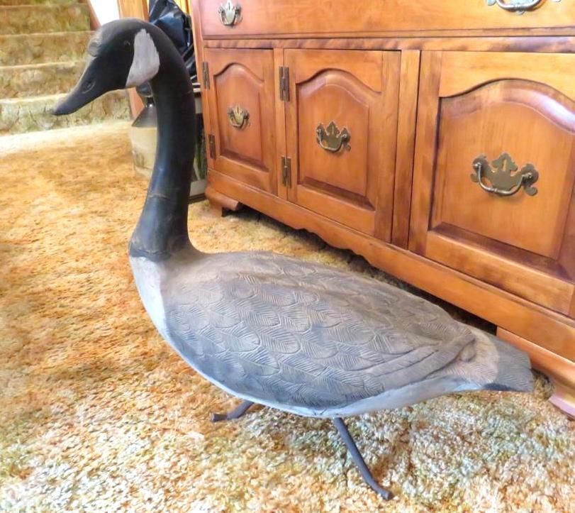A large Canada goose statue stands on a carpet.