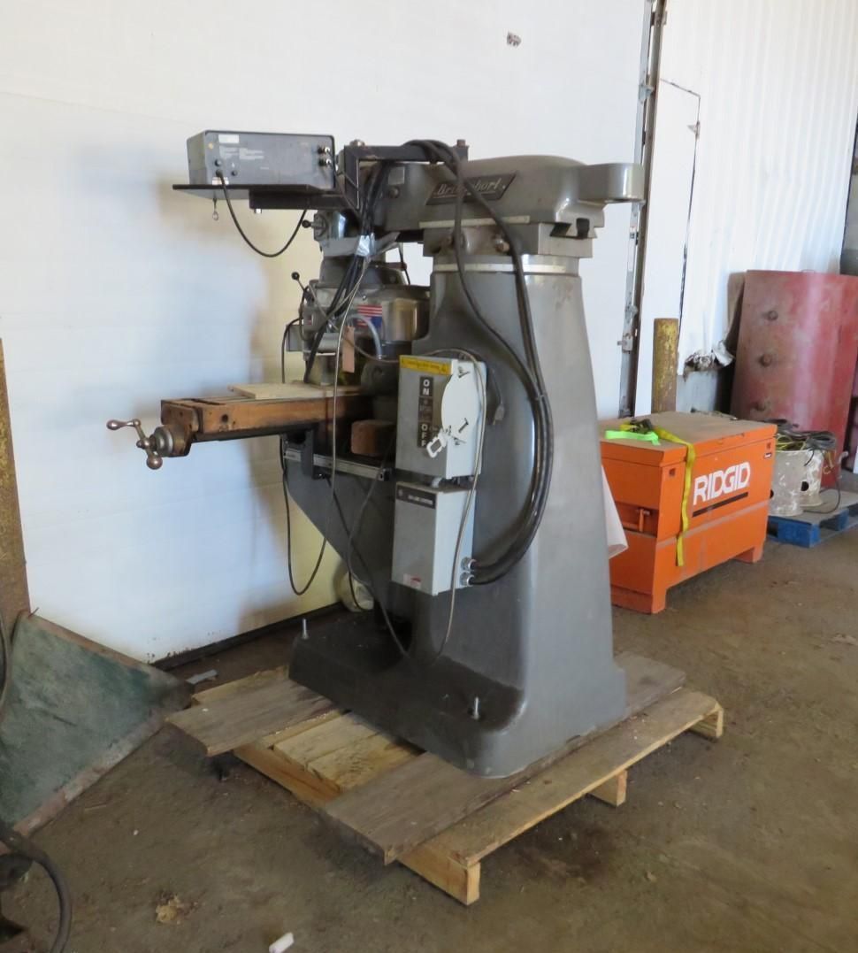 Gray milling machine on a wooden pallet, in a workshop setting.