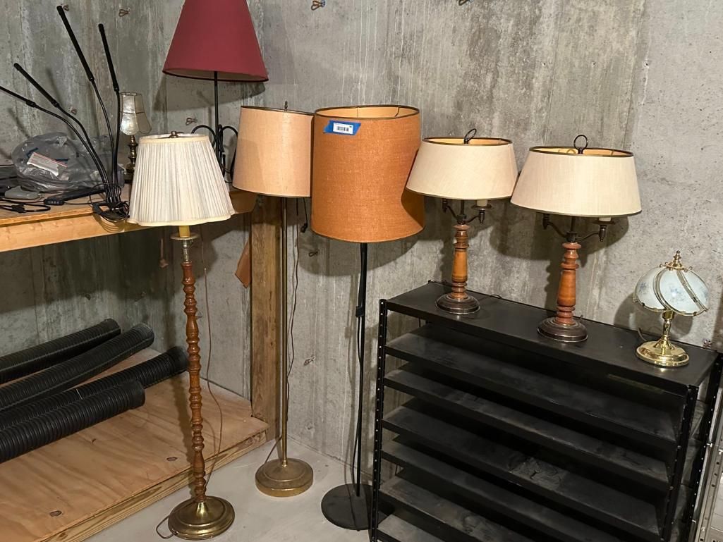 Collection of lamps with various shades on a shelf.