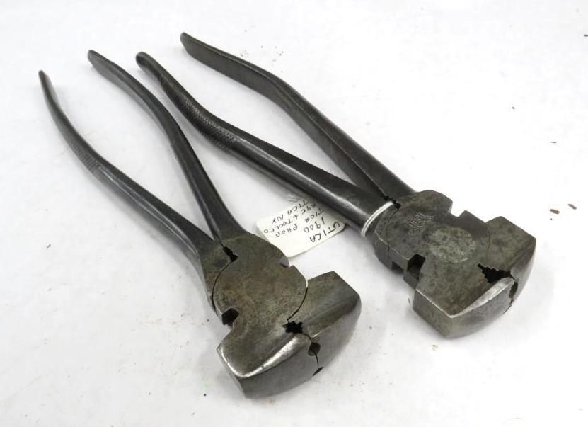 Two metal riveting tools. Dark, angled handles and squared heads sit on a white surface.