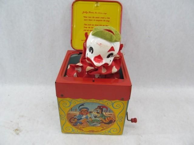 Jack-in-the-box toy with a clown, red and yellow box, crank on the side, lid open with poem.