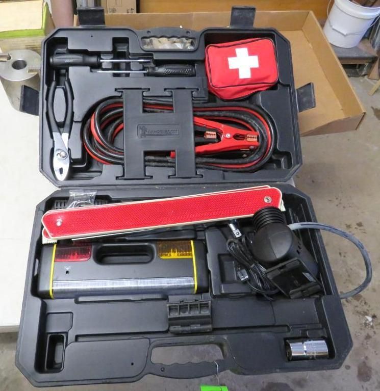 Black toolbox with emergency kit, jumper cables, and warning triangle.