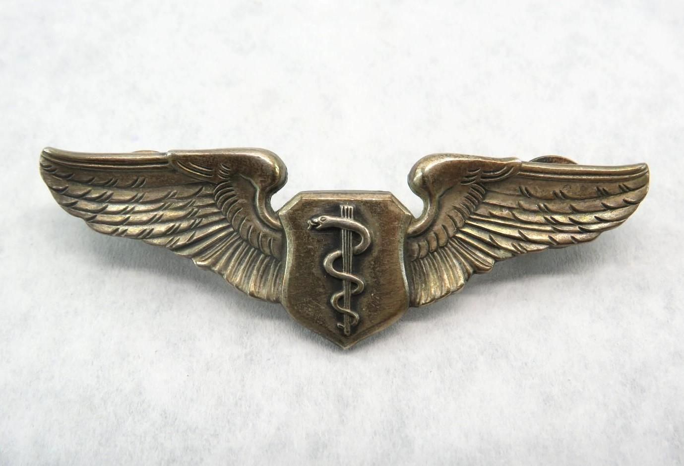Medical service badge with wings and the caduceus symbol.