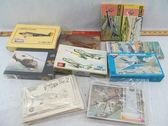 Collection of model airplane kits in various boxes, mostly vintage, arranged on a surface.