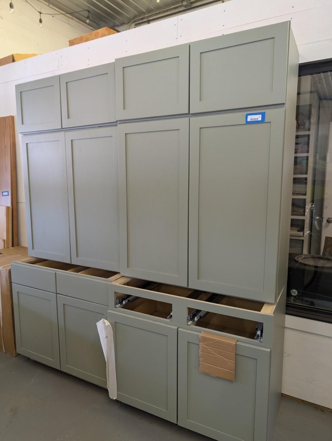 Gray kitchen cabinets in a room, waiting for installation.