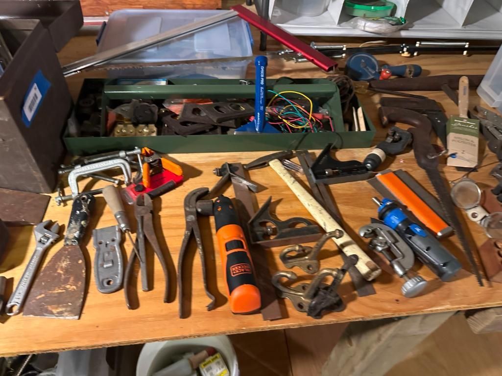 A workbench displays various tools including pliers, hammer, screwdriver, and a toolbox.