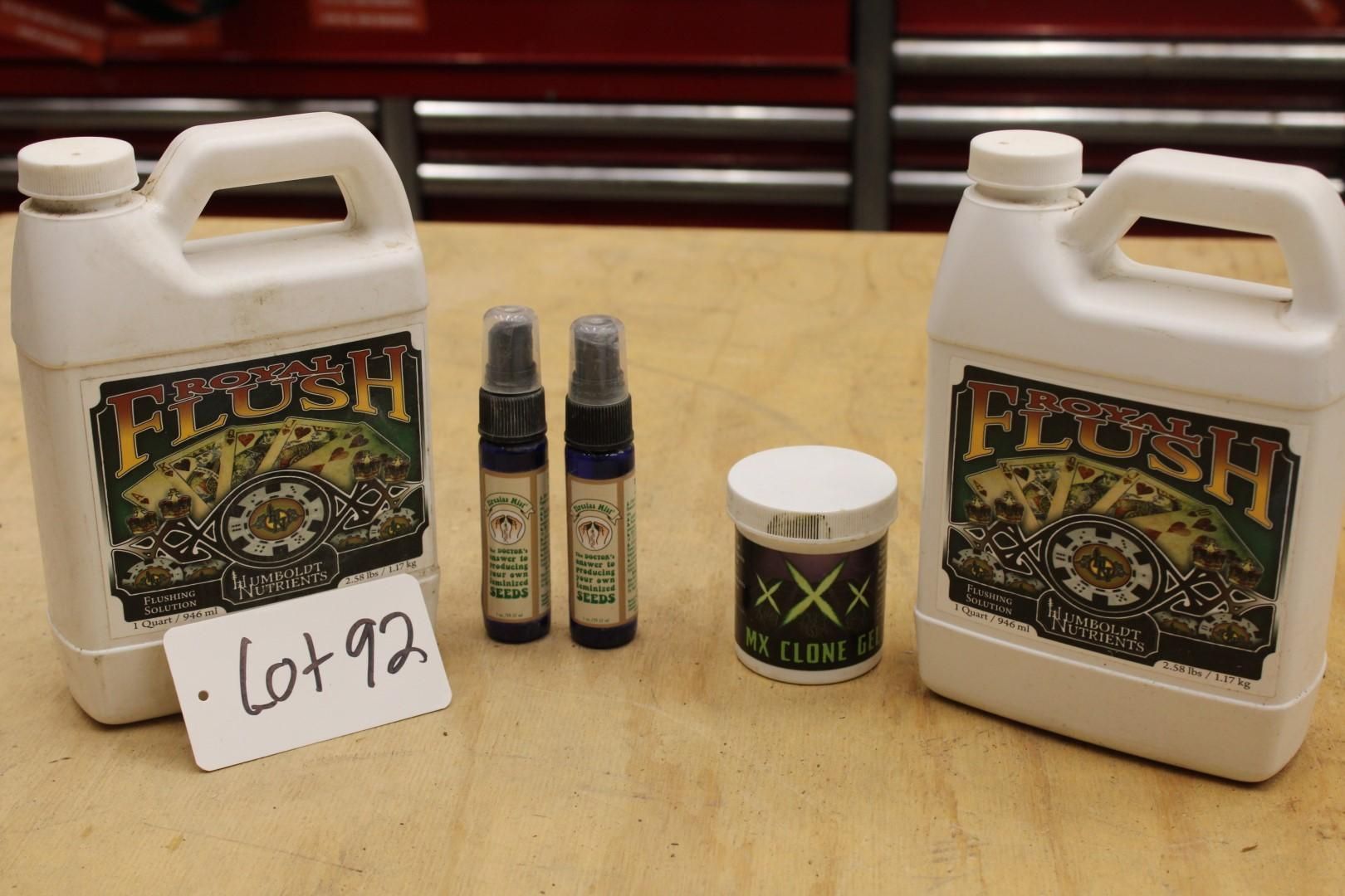 Two white plastic jugs, two spray bottles, and a jar on a wooden surface. All have product labels.