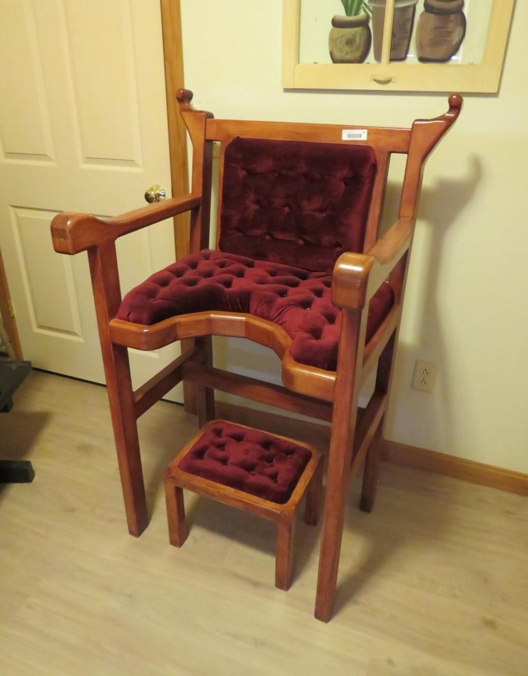 Wooden chair with burgundy velvet seat, back, and footrest.