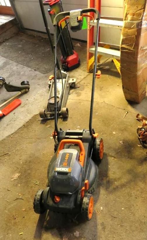 Electric lawnmower with orange accents, handle extended.