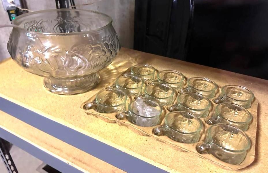 Clear glass punch bowl and cups with floral design on a wooden surface.