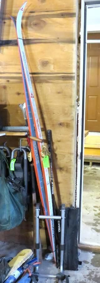 Skis leaning against a wooden wall, beside a doorway.