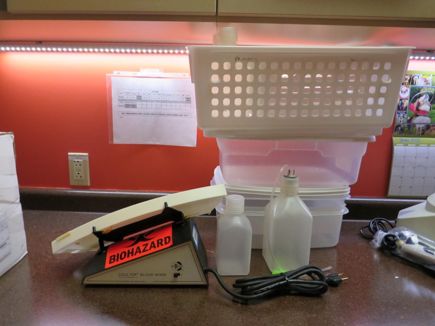 Biohazard scale with bottles, containers, and a basket on a counter.