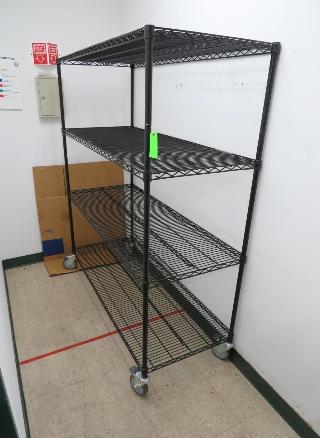 Black wire shelving unit on wheels in a room with beige walls and flooring.