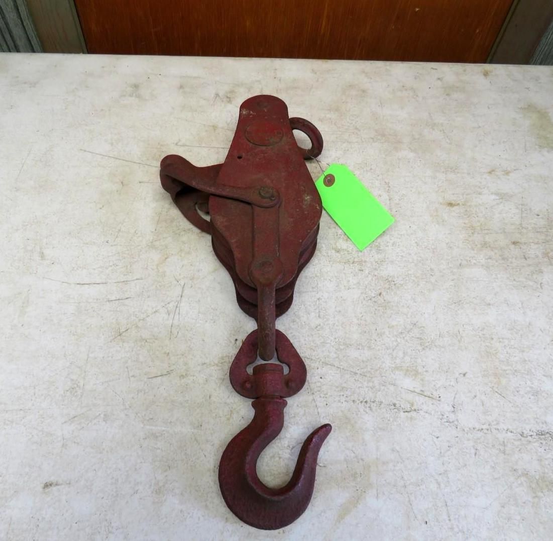Red, antique pulley system with a hook and tag.