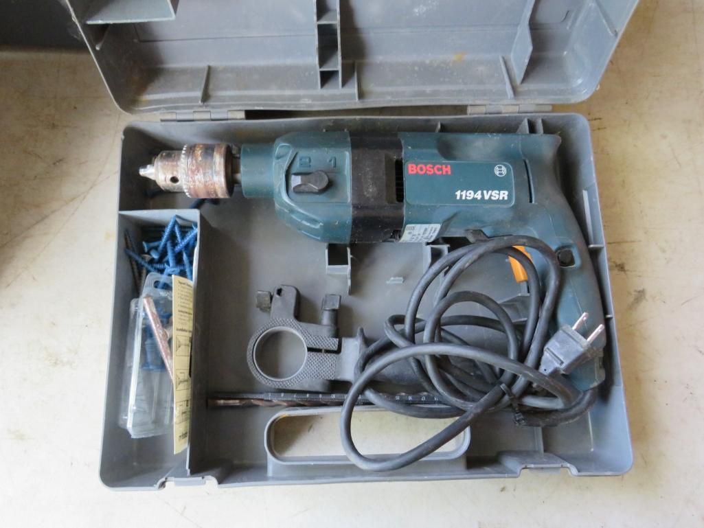Bosch power drill in gray case with accessories, including bits and fasteners.