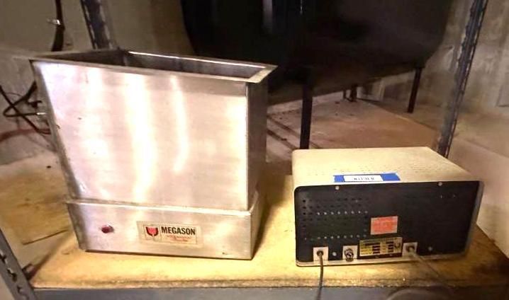 A stainless steel, rectangular Wilson brand tank and control unit on a shelf in a room.
