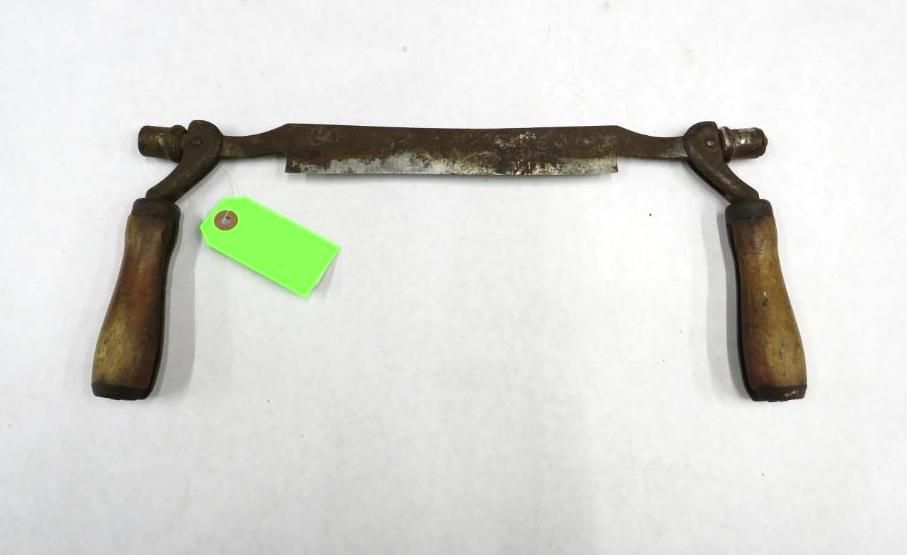 A drawknife with wooden handles on a white surface.