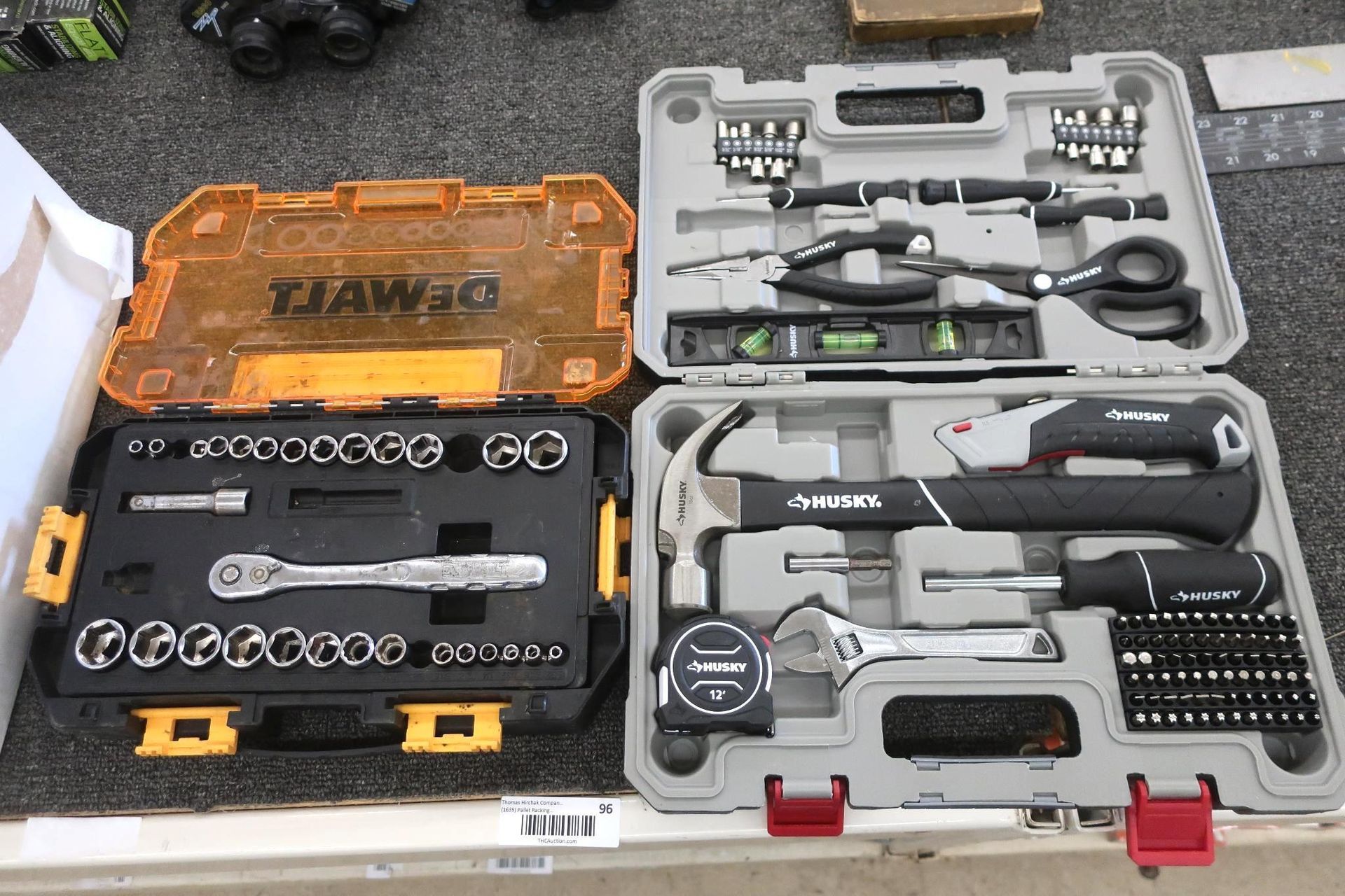 Toolboxes opened, containing sockets, screwdrivers, hammer, level, pliers, and other tools.