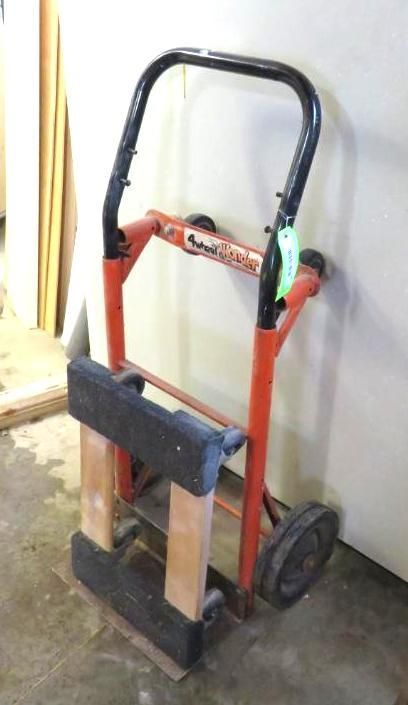 Orange and black hand truck with a curved handle and two wheels.
