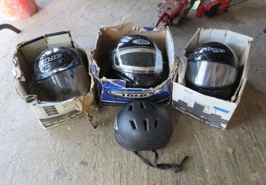 Three helmets in boxes and one helmet on the ground.