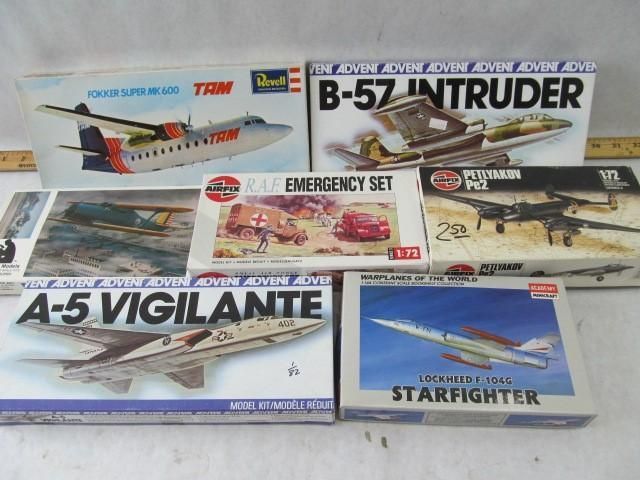 Model airplane kits, including TAM, B-57 Intruder, Emergency Set, and A-5 Vigilante, on a surface.