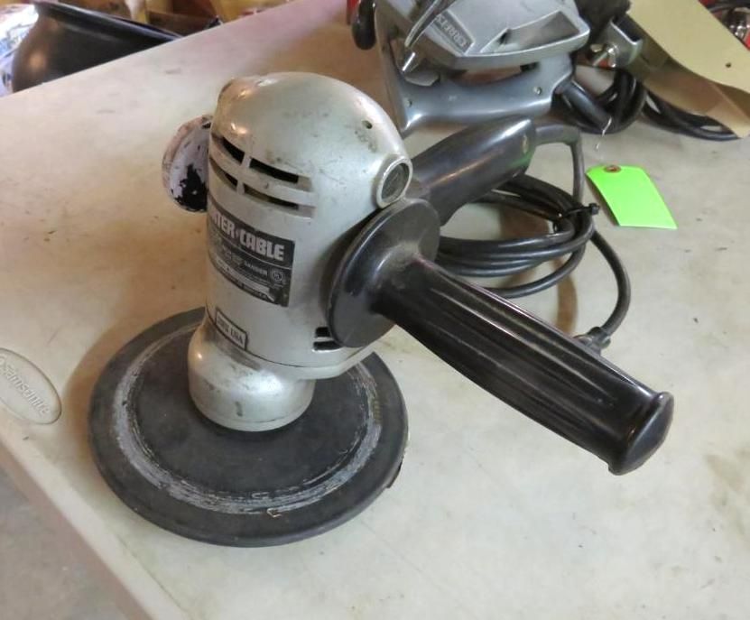 Silver and black Porter-Cable sander on a table. The tool has a circular base, handle, and power cord.