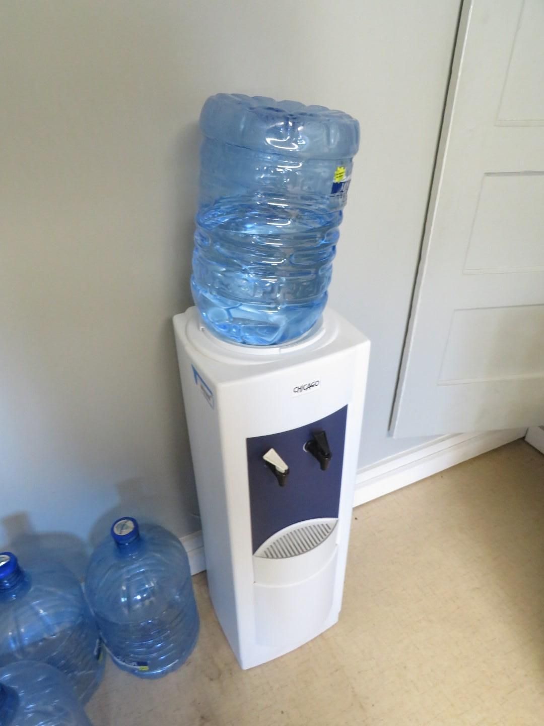Water cooler with large blue water bottle on top.