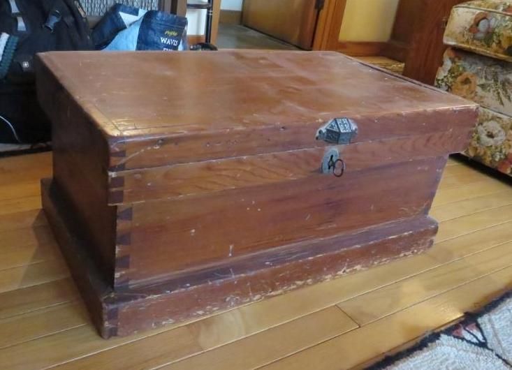 Wooden chest with a lock on a hardwood floor.