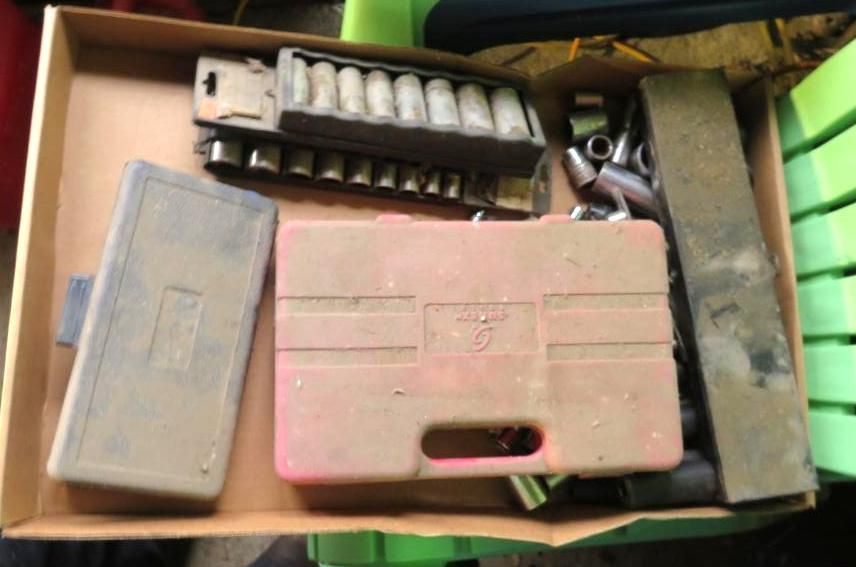Box containing tools including sockets, wrenches, and tool cases.