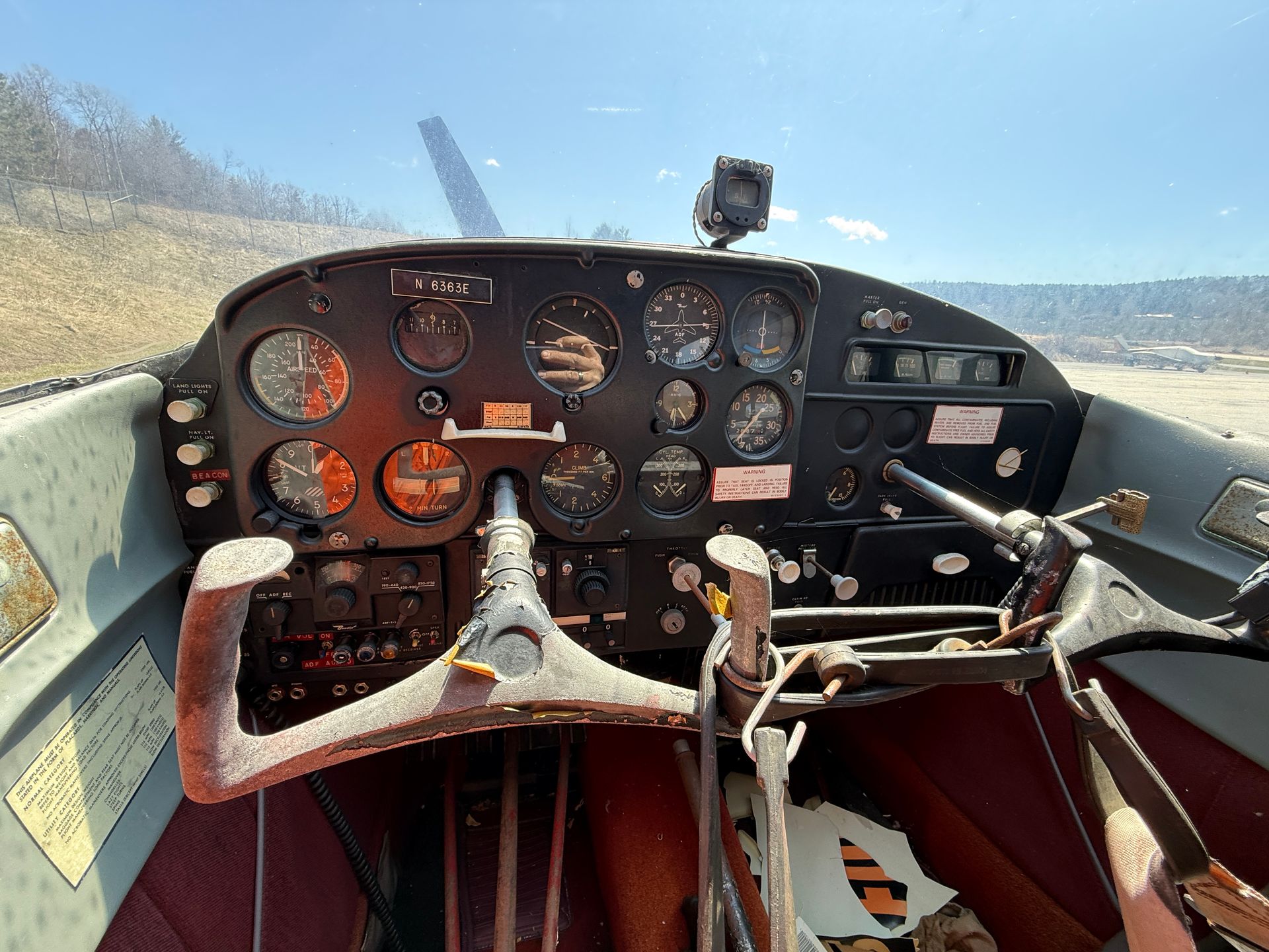 Cockpit view of a small aircraft with analog gauges and a central control yoke