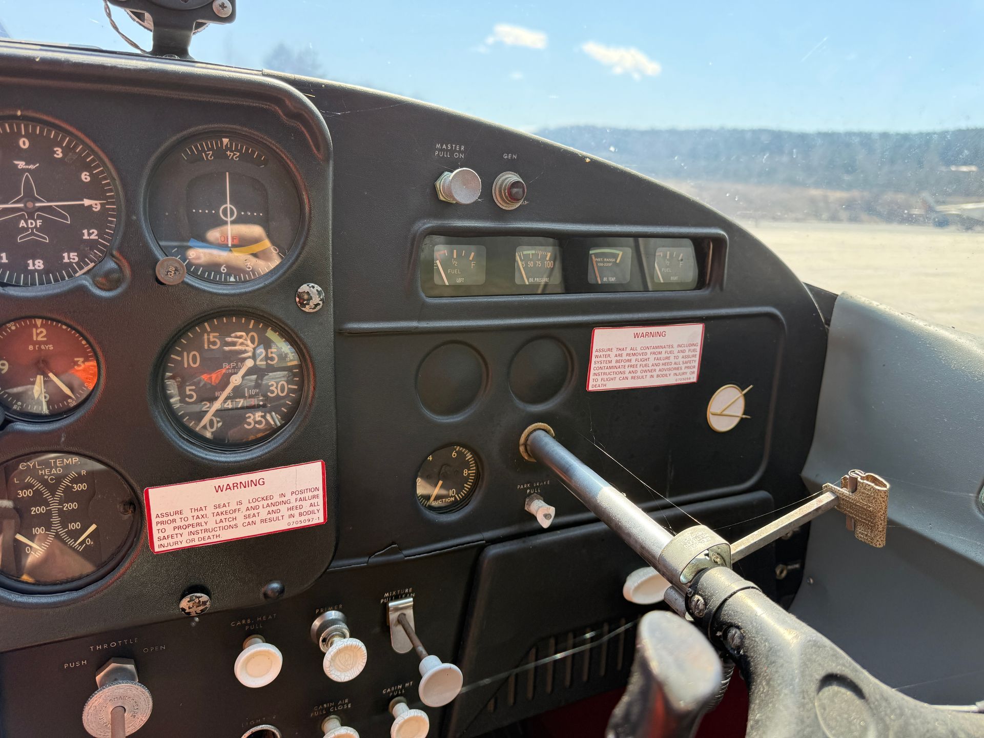Cockpit dashboard with gauges and controls, viewed from inside a small aircraft