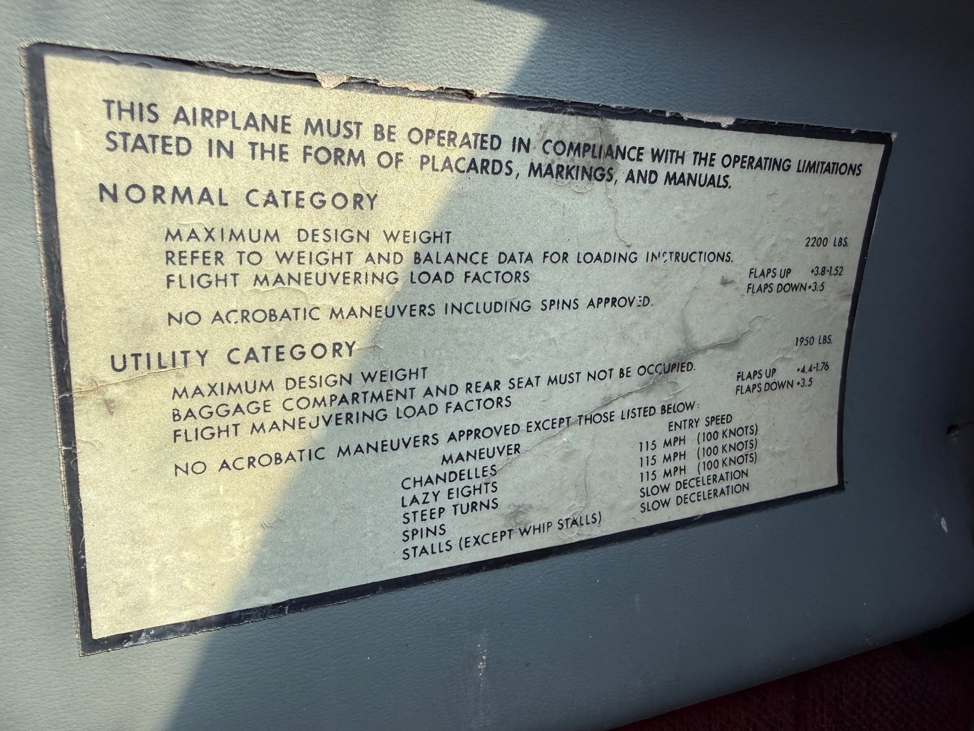 Airplane safety placard on a gray wall, listing normal and emergency operating procedures.