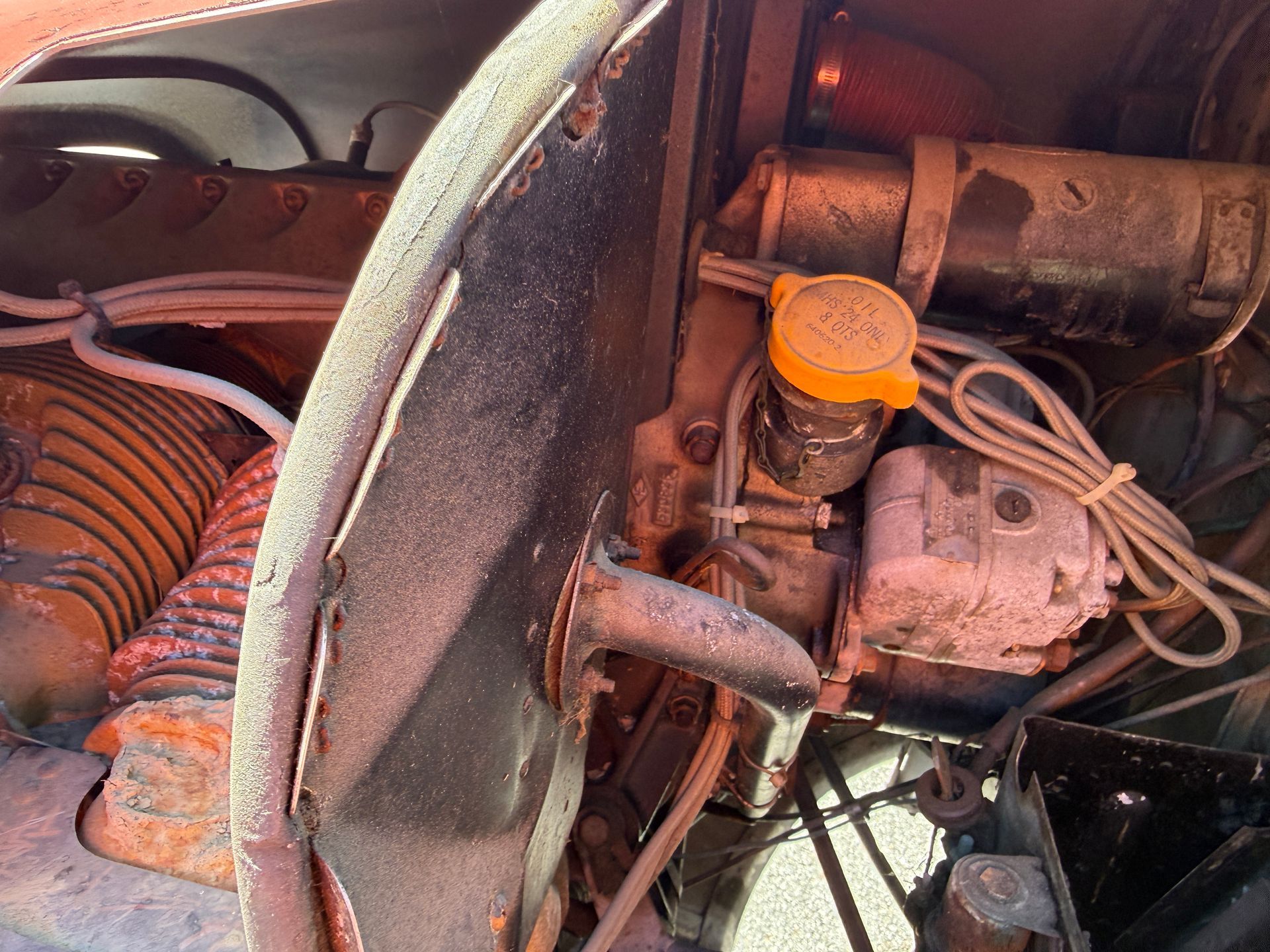 Engine compartment with orange cap and exposed cables inside an airplane
