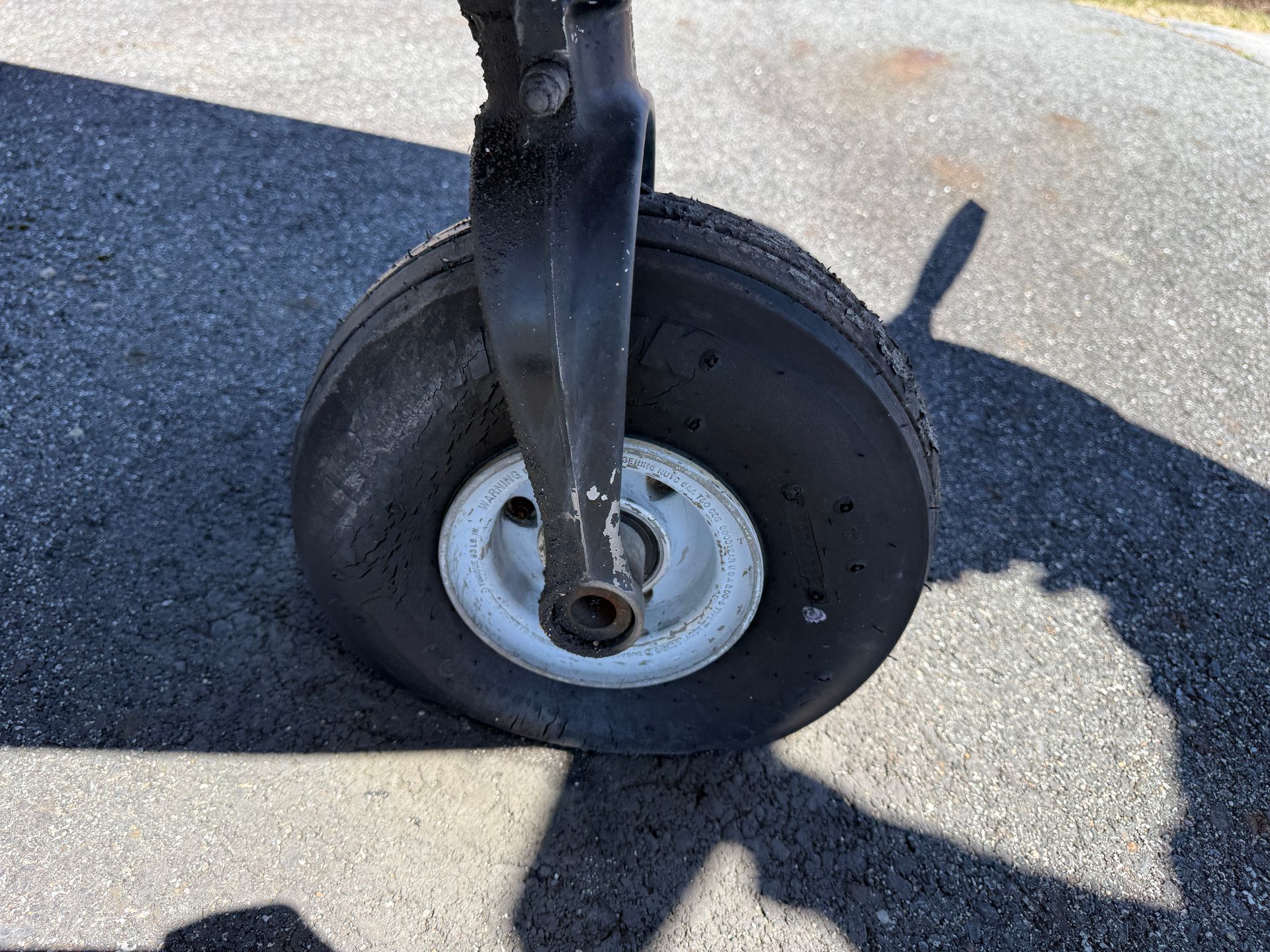 Close-up of an airplane landing gear wheel on a runway surface.