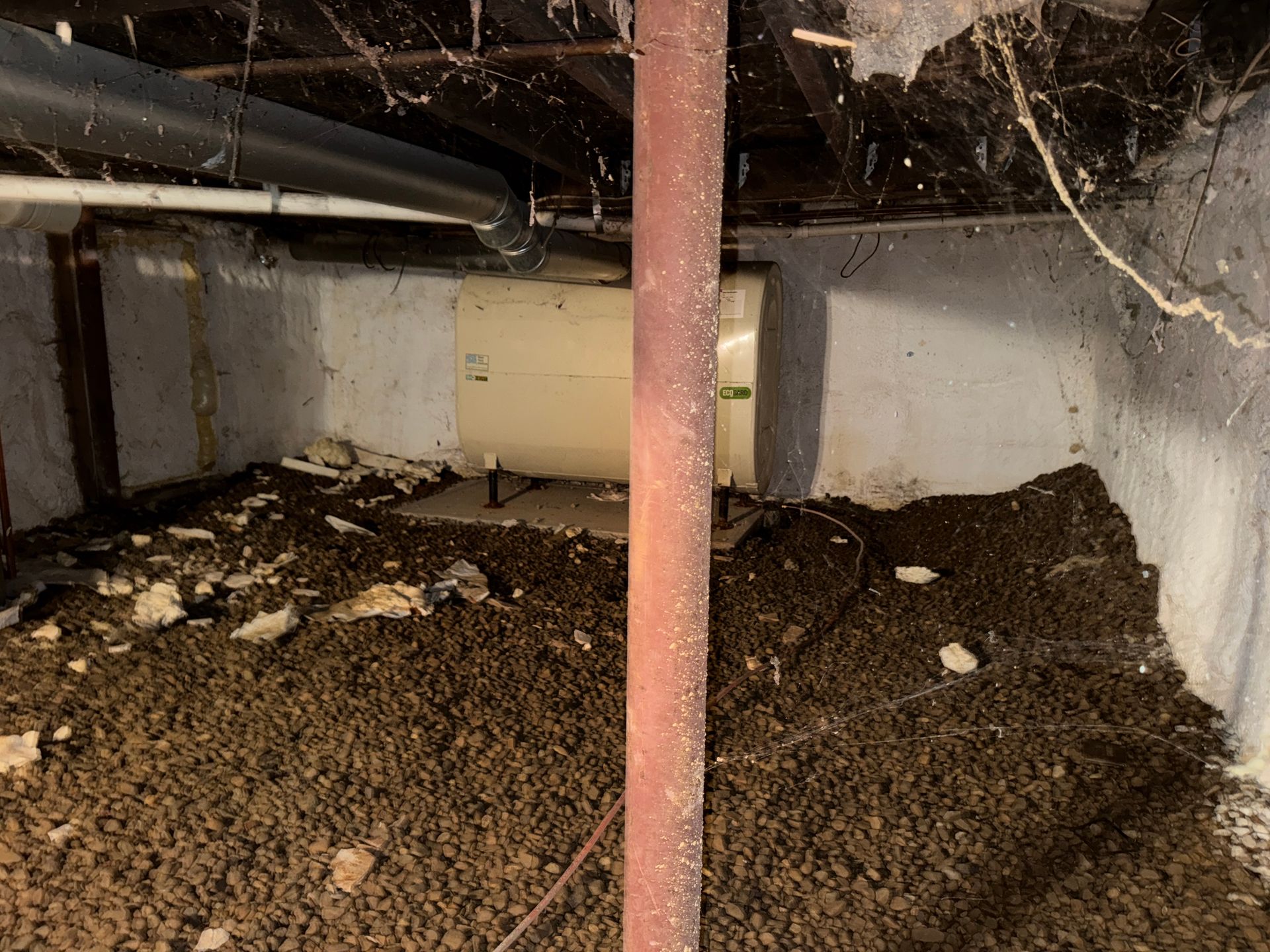 Basement crawlspace filled with dirt, with a red support post in the center.