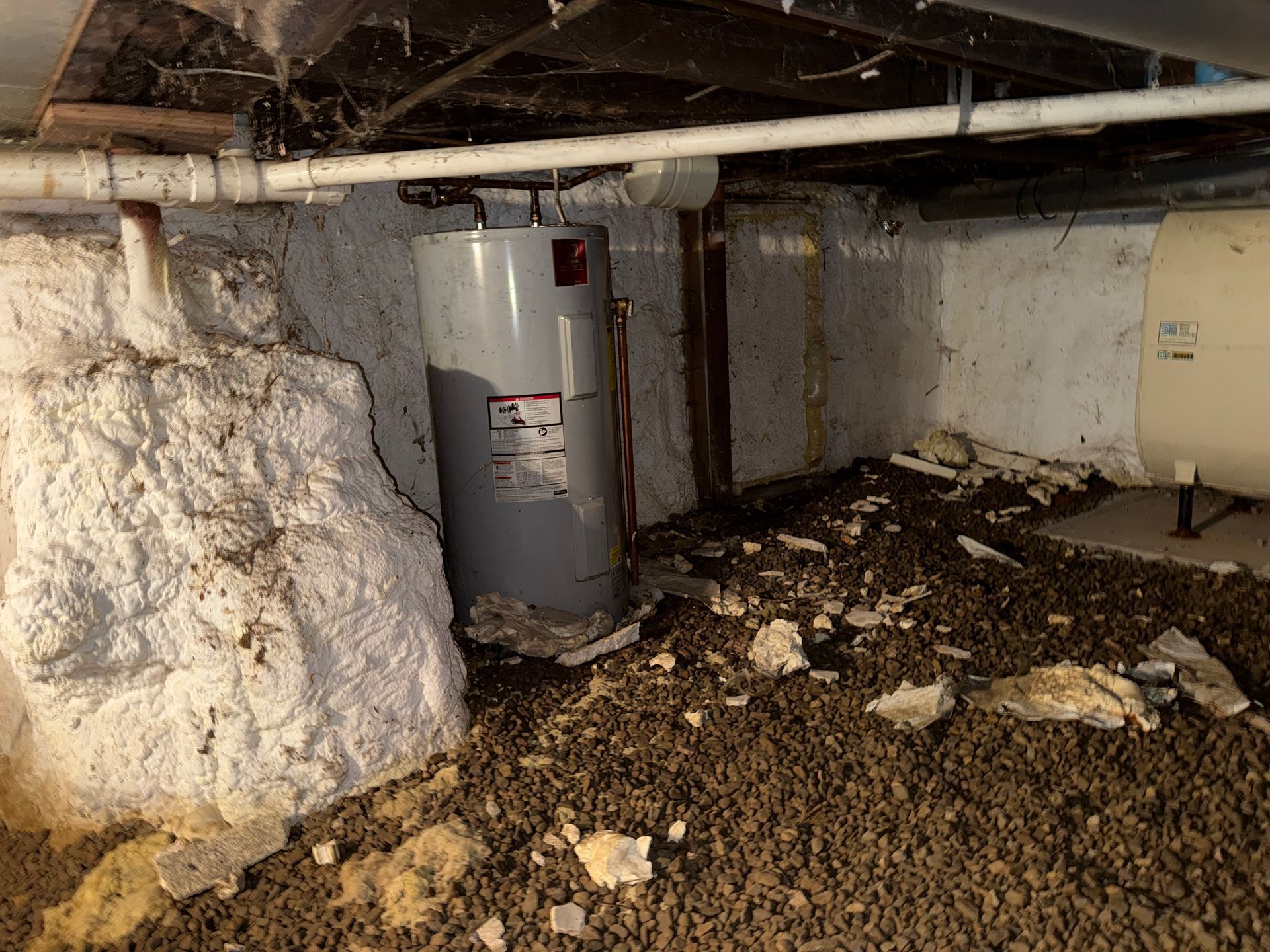 Crawl space with water heater, exposed pipes