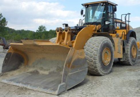 Yellow Caterpillar wheel loader with a large bucket on a construction site.
