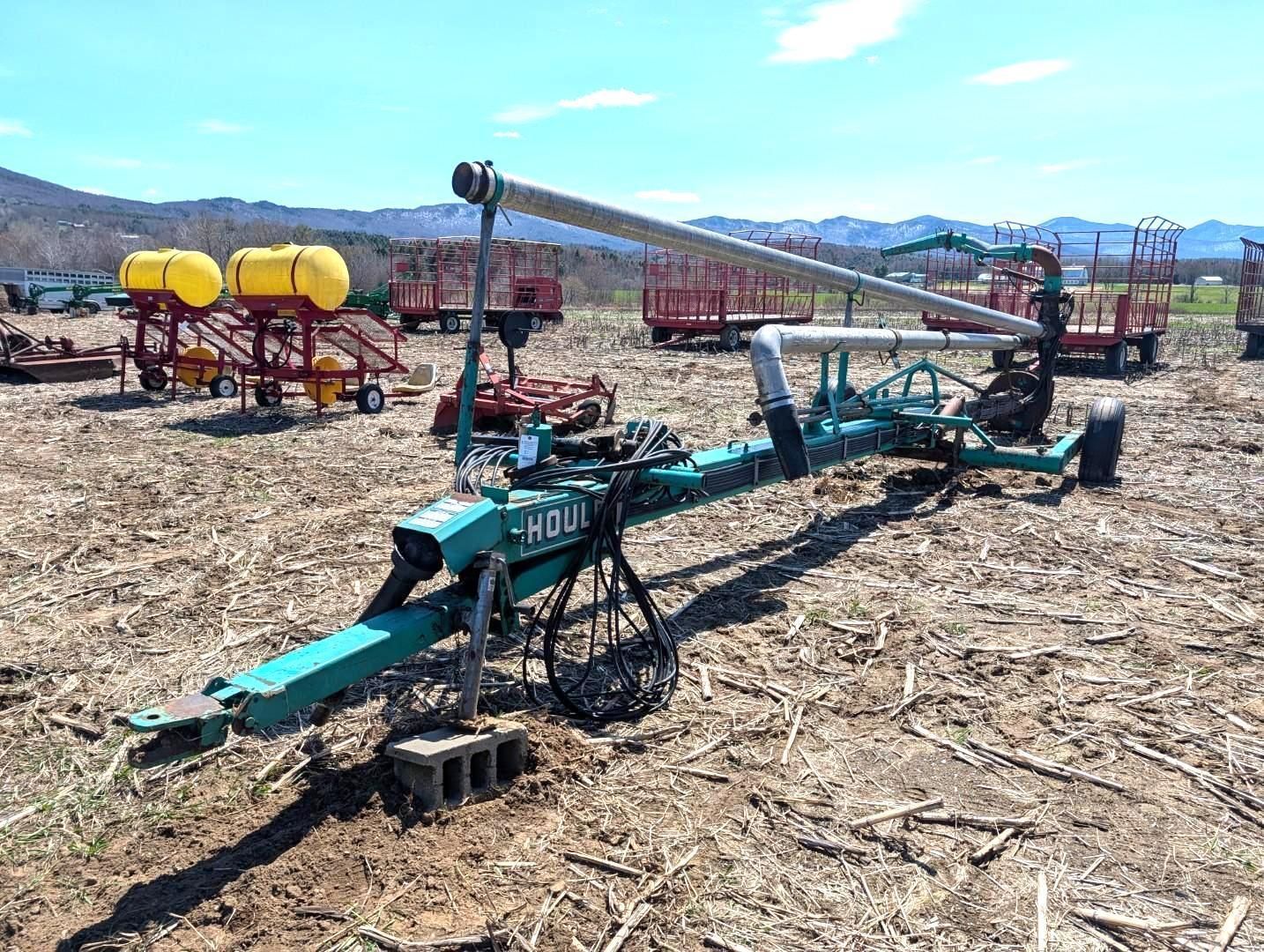 Farm equipment in a field with mountains in the background