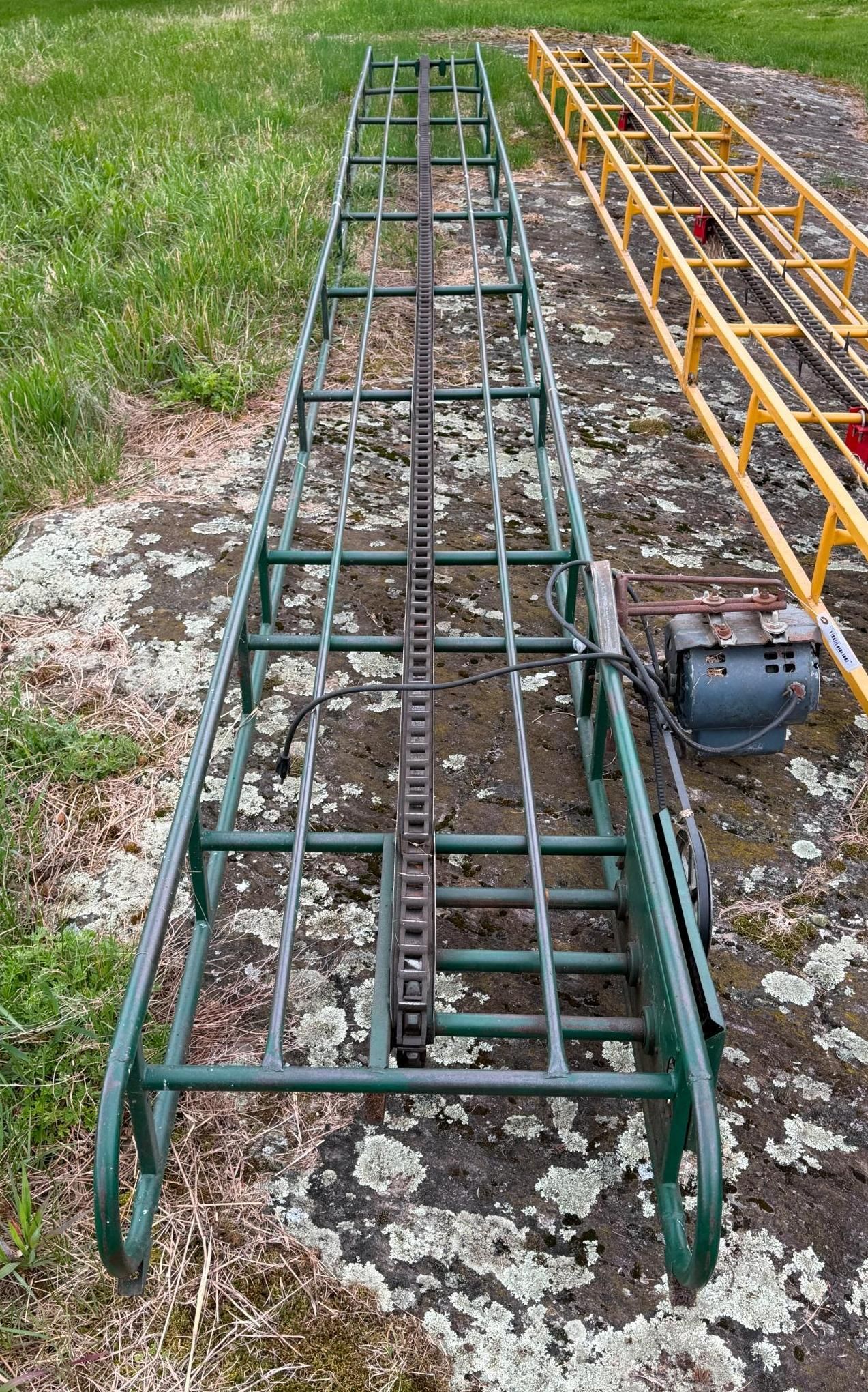 Two metal ladders or rack frames, green and yellow, lying on grass beside a gravel path.
