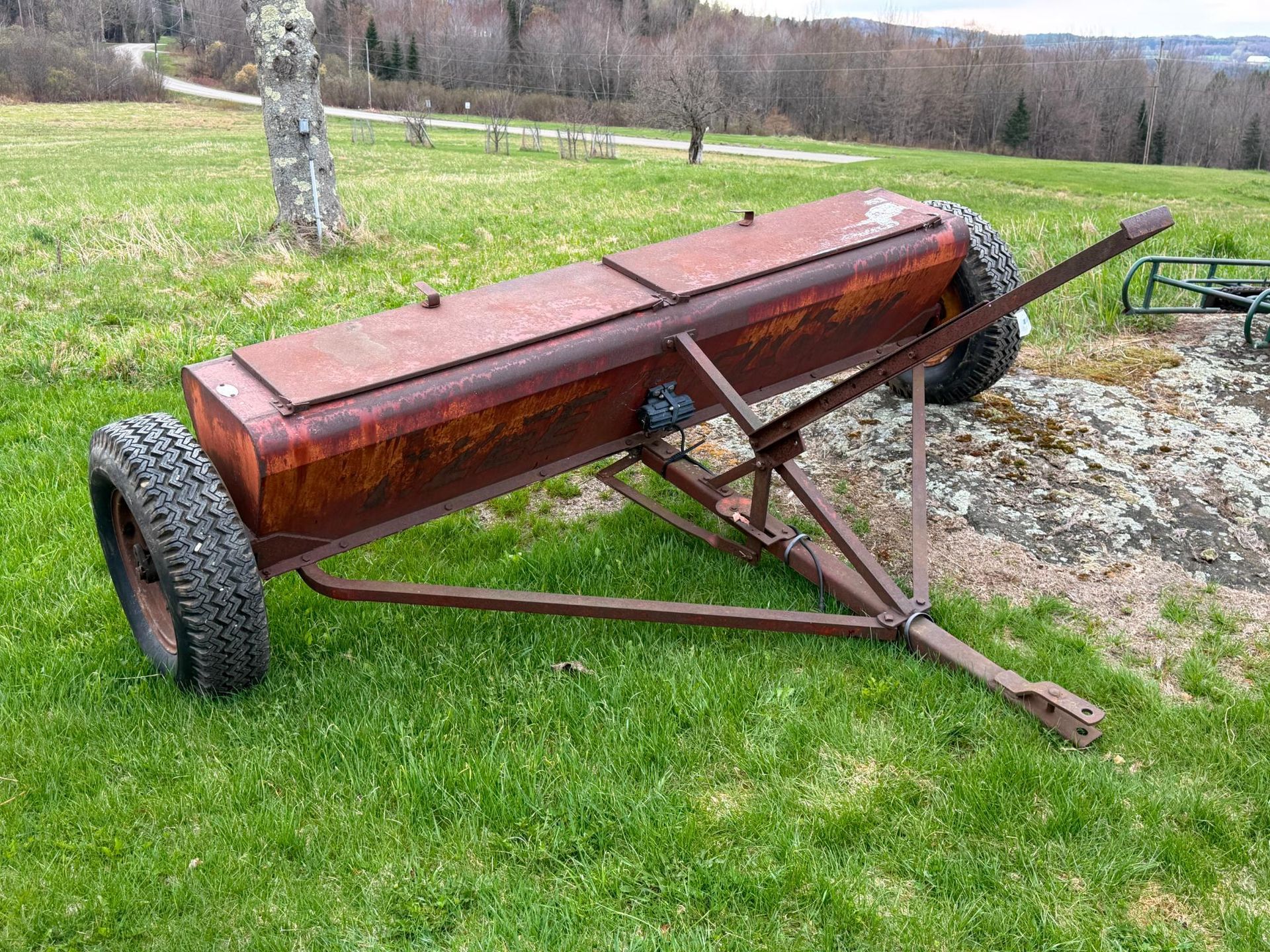 Red homemade trailer or farm cart on grass.