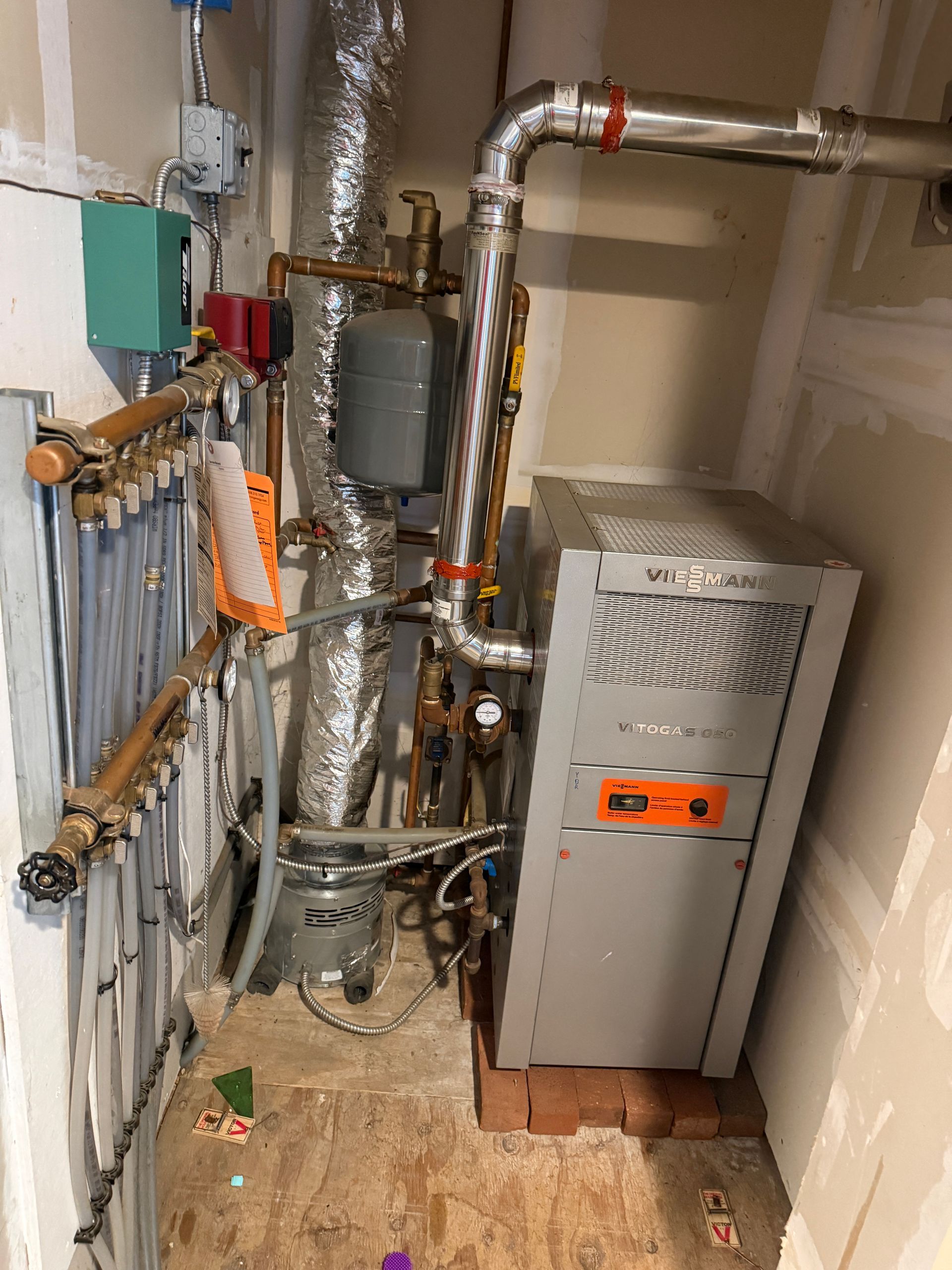 Utility room with exposed pipes, a gray furnace
